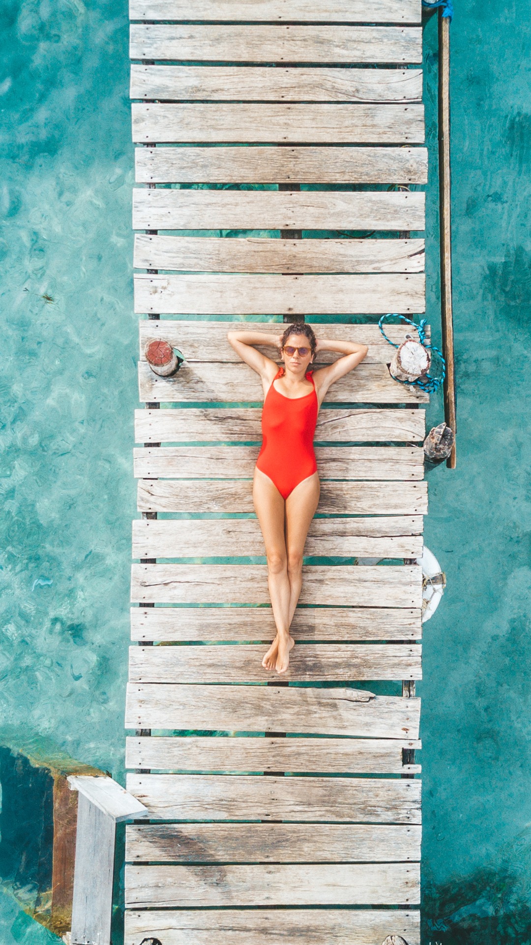 aerial shot of womann relaxing in a water bungalow picture id1034306790